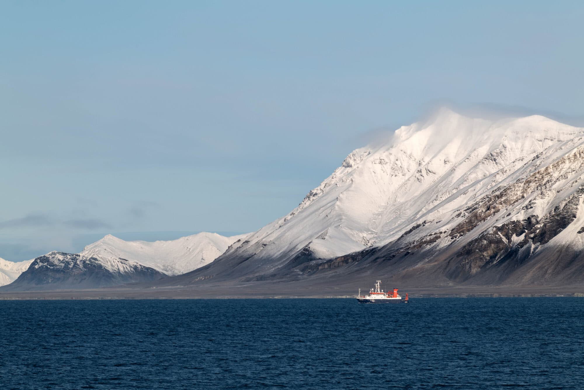 a large body of water with a mountain in the background